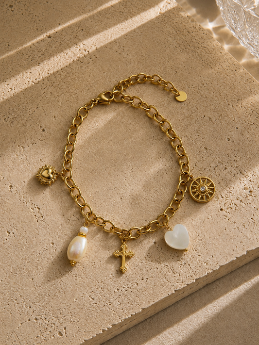 Bracelet charms croix céleste doré – médaillon soleil strass, cœur nacré, croix gothique ciselée et perle baroque – Bijoux Incandescence"