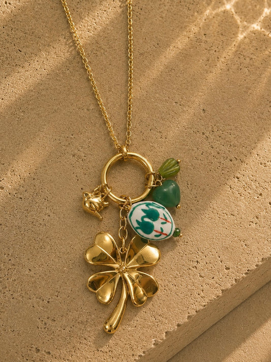 Détail collier charms trèfle et médaillon doré – trèfle bombé, oiseau doré, médaillon porcelaine chinoiserie et aventurine verte – Bijoux Incandescence