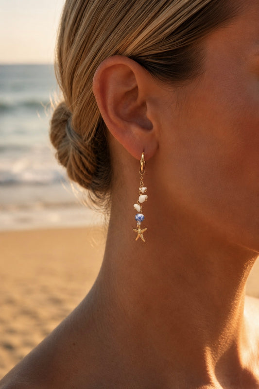Boucles d'oreilles perles bleues portées – créoles dorées avec chaîne, perles nacrées, céramique bleue et étoile de mer – Bijoux Incandescence