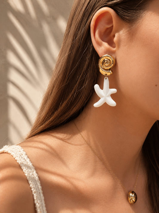 Boucles d'oreilles étoile de mer portées – pendentif étoile blanche et puce coquillage spirale dorée, look balnéaire chic – Bijoux Incandescence
