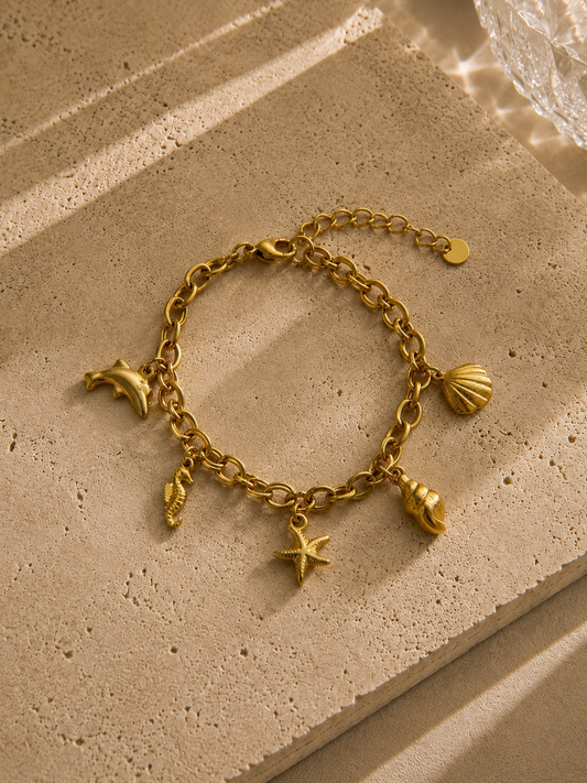 Bracelet charms dauphin doré – chaîne épaisse avec 5 charms marins : coquille, escargot, étoile de mer, hippocampe et dauphin – Bijoux Incandescence