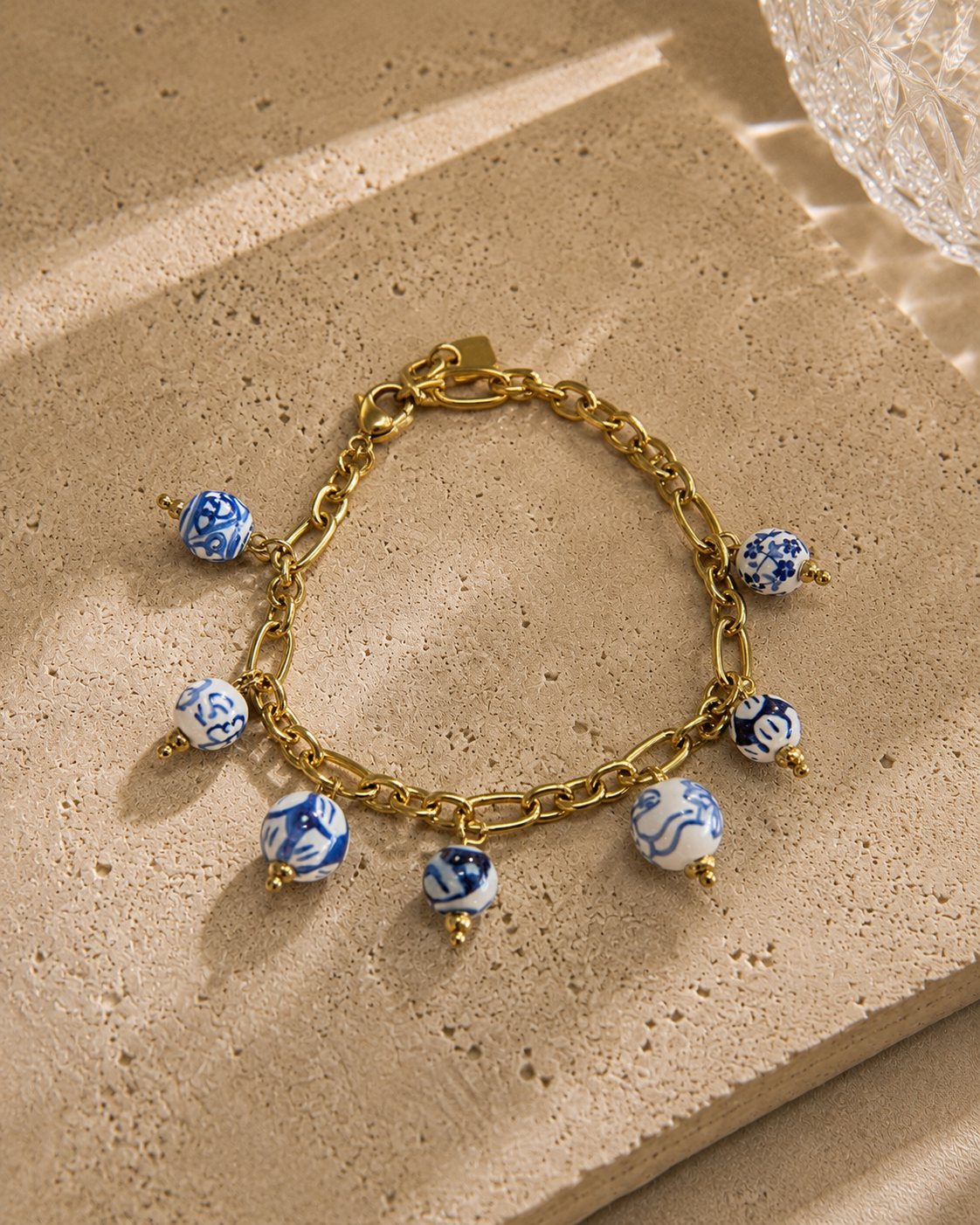 Bracelet charms perles bleues et blanches en céramique motifs porcelaine – chaîne dorée en acier inoxydable avec charm feuille, style artisanal chic – Bijoux Incandescence
