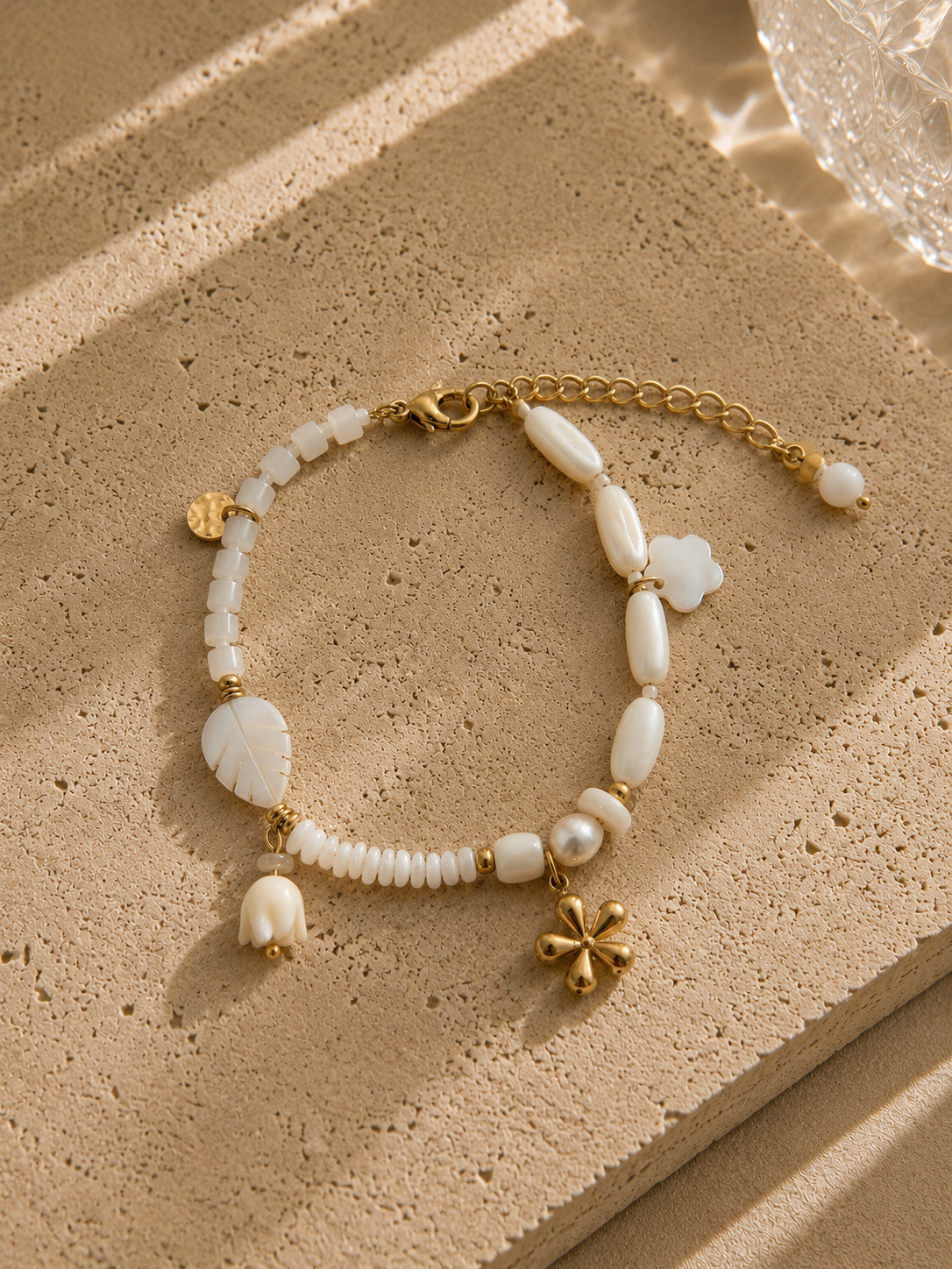 Bracelet charms perles et fleurs nacrées – rang de perles baroques blanches avec charms trèfle nacré, fleur nacrée et trèfle doré bombé, style romantique – Bijoux Incandescence