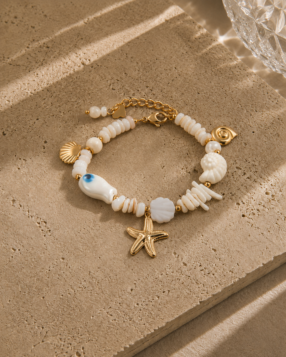 Bracelet trésor marin – perles nacre blanche variées avec charms étoile de mer dorée, coquillages nacrés, escargot et perle œil bleu, style bord de mer luxe – Bijoux Incandescence