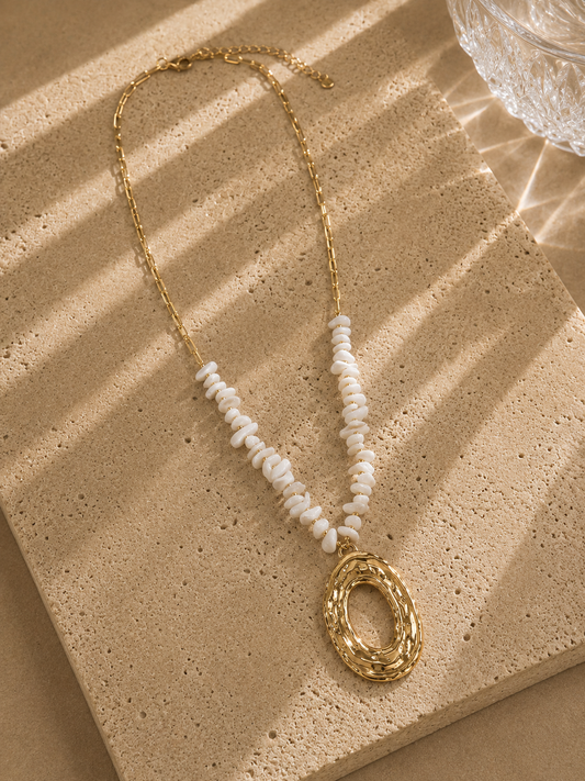 Collier long pendentif ovale doré martelé – demi-chaîne paperclip et rang de chips de nacre blanche, grand pendentif ovale ajouré texturé, style statement éditorial – Bijoux Incandescence