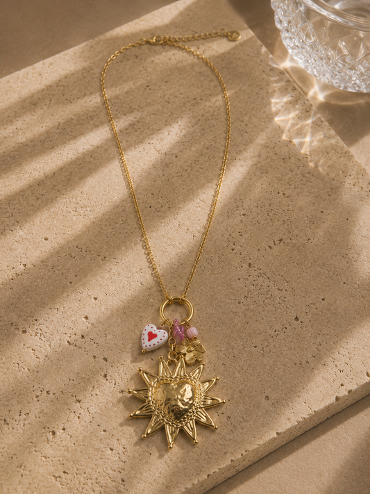 Collier long soleil et fleur doré – grand médaillon soleil baroque ciselé avec visage en relief, charm cœur émaillé à pois rouges et perle rose, style bohème statement – Bijoux Incandescence